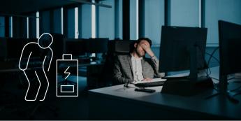 Mann sitzt erschöpft nachts im Office