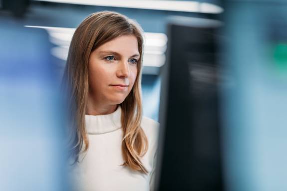 Blonde Frau schaut auf einen Computerbildschirm